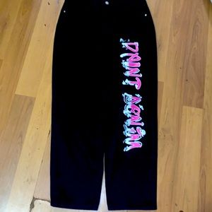 Black & pink writing as “paint denim”. Never worn size L flare and wide jeans